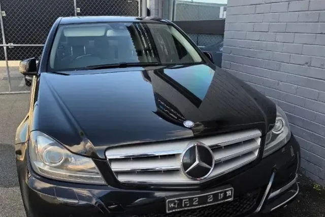 Black Mercedes-Benz C-Class parked on a driveway before a mobile service