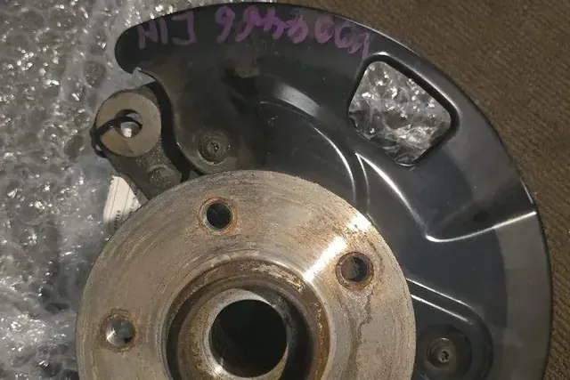 Rear wheel hub and backing plate removed from a car for a bearing replacement
